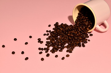 Shot of a pink cup with coffee beans on pink background