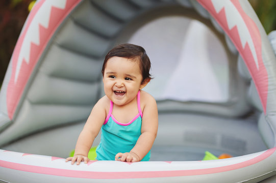 Happy Smiling Baby Girl In Backyard Pool