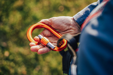 Climbing carabiner cliped or connected to a climbing harness. Climber wearing a harness with biner...