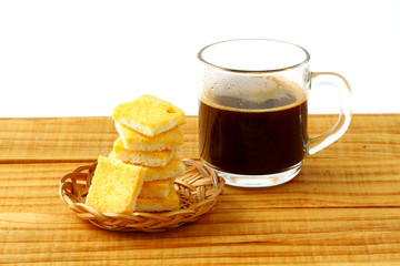 crispy butter and sugar bread in bamboo basket and hot black coffee on wooden board. snack for relax time