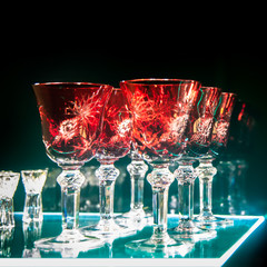Set of colored crystal glasses on a dark background, selective focus