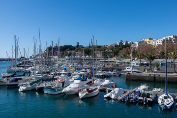 View over Funchal harbour with a lot of sailboats and and a blue sky in background
