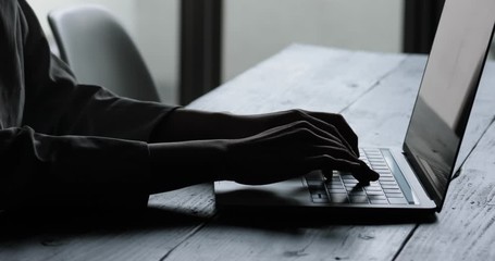 クレジットカードを持ちパソコン作業をする若い女性のシルエット姿 Wall Mural West Photo