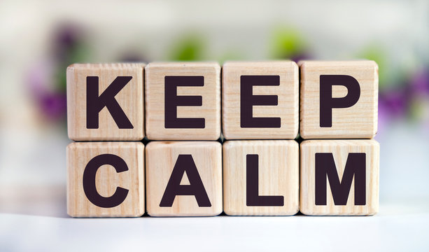 KEEP CALM - text on wooden cubes on a floral background with tulip buds