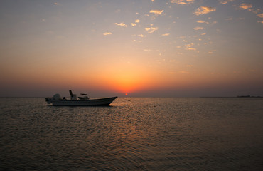 Naklejka na ściany i meble Speed boat and beautiful sunset, Bahrain
