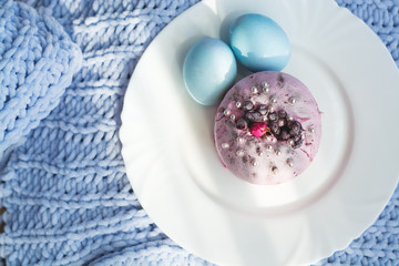Easter bread, cake and eggs with decor of flowers, beads and nuts. Blue knitted plaid. The concept of the Easter holidays and decor.