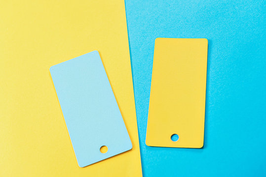 abstract composition of 2 design cards, comparison of two yellow and blue colored cards on a two-color paper background