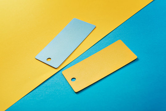 abstract composition of 2 design cards, comparison of two yellow and blue colored cards on a two-color paper background