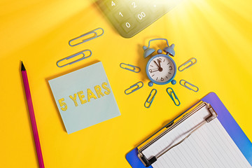 Writing note showing 5 Years. Business concept for Remembering or honoring special day for being 10 years in existence Alarm clock clipboard pencil calculator notepad colored background