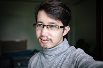 Fototapeta na wymiar Portrait of Asian man taking selfie photo, Close up face of Asian man with eyeglasses