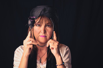 Fototapeta premium Woman with dead black rose under veil