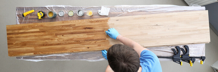 Woodworker varnishing surface