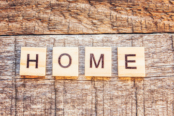 Stay Home Stay Safe. Inscription HOME letters word on wooden background. Social distancing awareness. Sweet home COVID-19 Coronavirus quarantine concept.