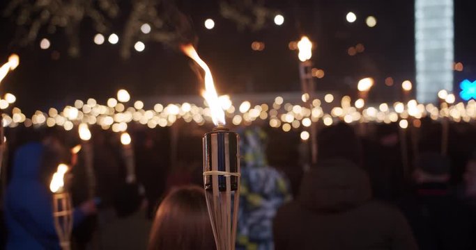 Torchlight procession march at night people with burning torches