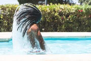 Rastafari Man Throwing Water with his Hair in Swimming Pool. Lifestyle Concept.