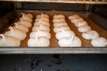 freshly baked meringue lies on a baking tray in the oven