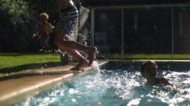 Child getting out of the pool water. Young boy exits stepping out of swimming pool