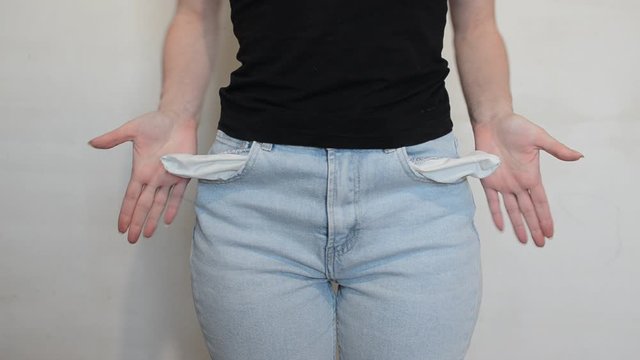 Woman in jeans twists empty pockets