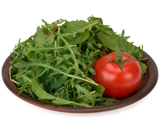 Mix of fresh lettuce, chard, arugula, mizuna and one tomato top view on a plate isolated on a white background