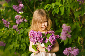 portrait girl in pink dress near lilac flowers