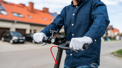 Obraz premium riding a scooter - communication around the city, coronavirus pandemic - COVID-19