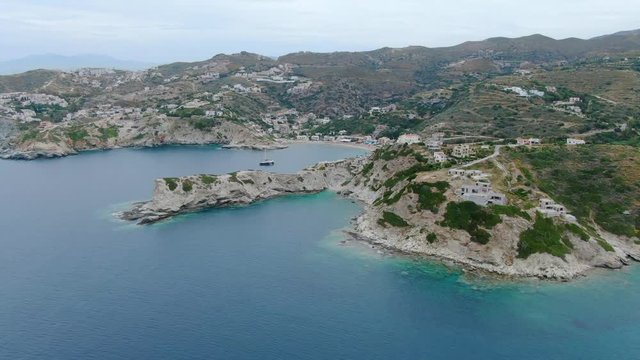 Wide angle dolly in drone aerial shot of beautiful beaches, houses, hills, and mountains in Creta Islands, Greece during the day