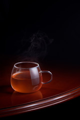 Cup of red tea on a luxurious table with a black background