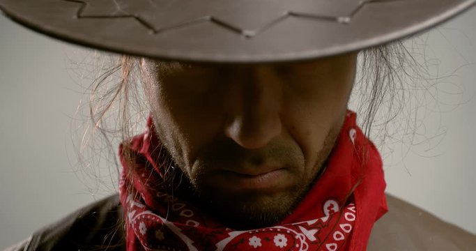 Portrait footage of a gunslinger looking from under his hat, 4k