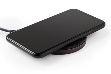 The smartphone is charged by a wireless charger  Concept of new technologies.