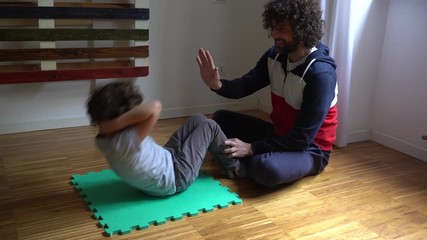 Europe, Italy , Milan - Father and children boy five years with mask at home during quarantine due n-cov19 Coronavirus outbreak - life style in apartment - gymnastic exercises to keep fit - Powered by Adobe