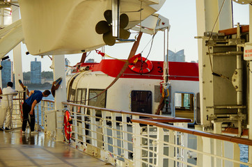 Boat or promenade deck of cruiseship or cruise ship liner with crew testing life boats © Tamme Wichmann