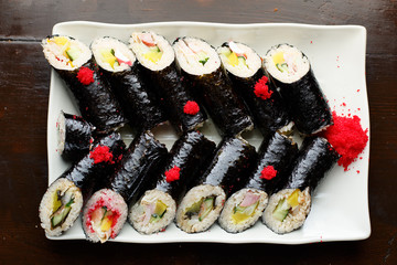 set of Korean rolls in a black shell on a white plate top view