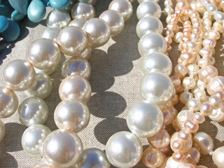  Pearl necklaces on light textured fabric beads shimmer in the light   