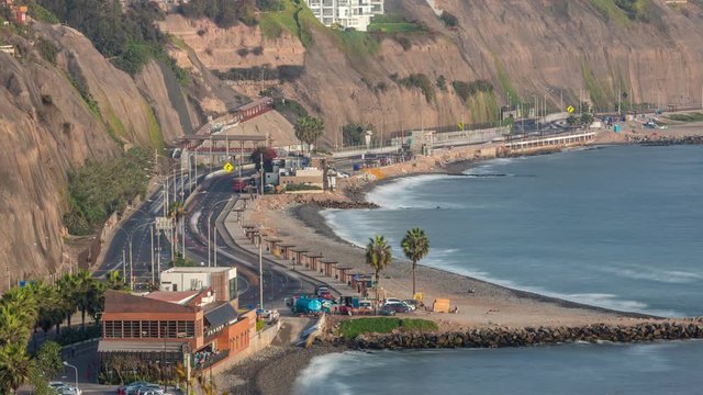 Traffic on Circuito de Playas road in Miraflores district of Lima aerial timelapse. City skyline and beaches on a background