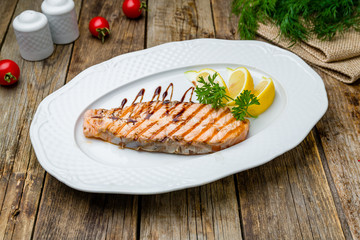 Salmon steak on the grill on wooden table