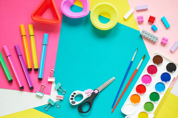 School supplies, stationery on blue background - space for caption. Child ready to draw with pencils and make application of colored paper. Top view.