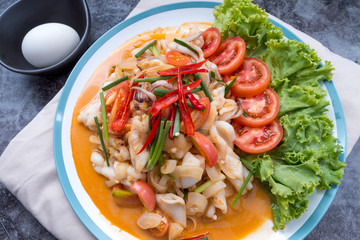 Stir-fried squid with salted egg yolk, onion, spring onion and Chili pepper on white plate. Food concept. Thailand seafood cuisine. thai food