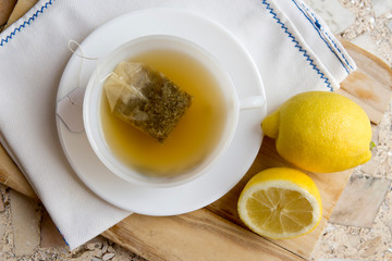 cup of chamomile tea with lemon on a neutral background