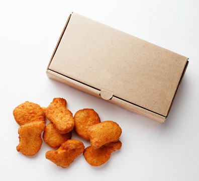 Large nuggets and cardboard box for them on a white closeup background