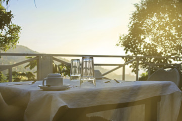breakfast table on outdoor terrace, sunlight