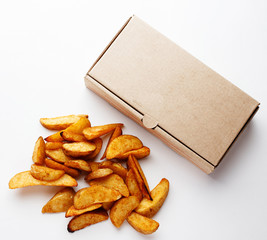 potato wedges and a cardboard box on a white closeup background