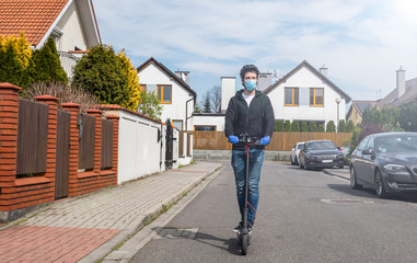 Fototapeta na wymiar man in a medical mask rides an electric scooter