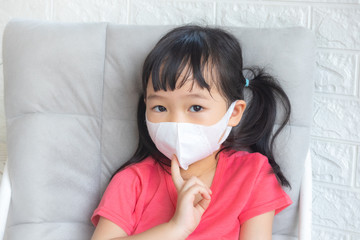 Little girl wearing mask for protect pm2.5 and Covid-19,sadness child at home in isolation,Coronavirus and Air pollution pm2.5 stop corona virus outbreak.Wuhan coronavirus and epidemic virus symptoms.