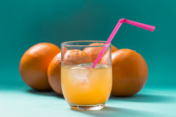orange juice and oranges on blue background