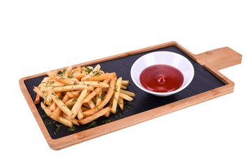 French fries with herbs and ketchup on a wooden board isolated on a white background.