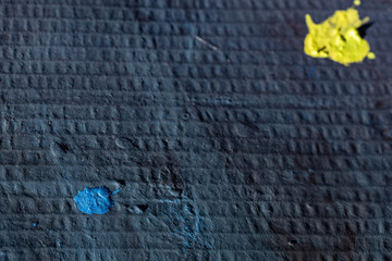 Dark blue background with blue and yellow spot drawn in gouache on cardboard