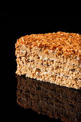 Delicious Napoleon cake with honey crisp on top. Confectionery photography concept in black background. Piece of cake