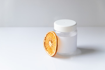 Cosmetic bottle for liquid, cream, gel, lotion. Hand sanitizer. Organic natural science beauty product. Battle with slice of orange