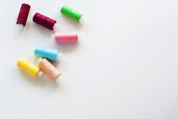Colored sewing threads on a white background, top view