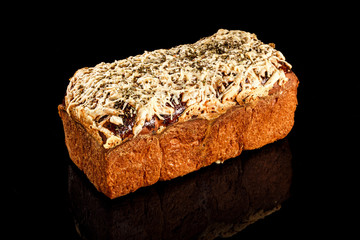 Kulich bread with melted mozzarella cheese and dried rosemary on top. Photography for bakery concept in black background.